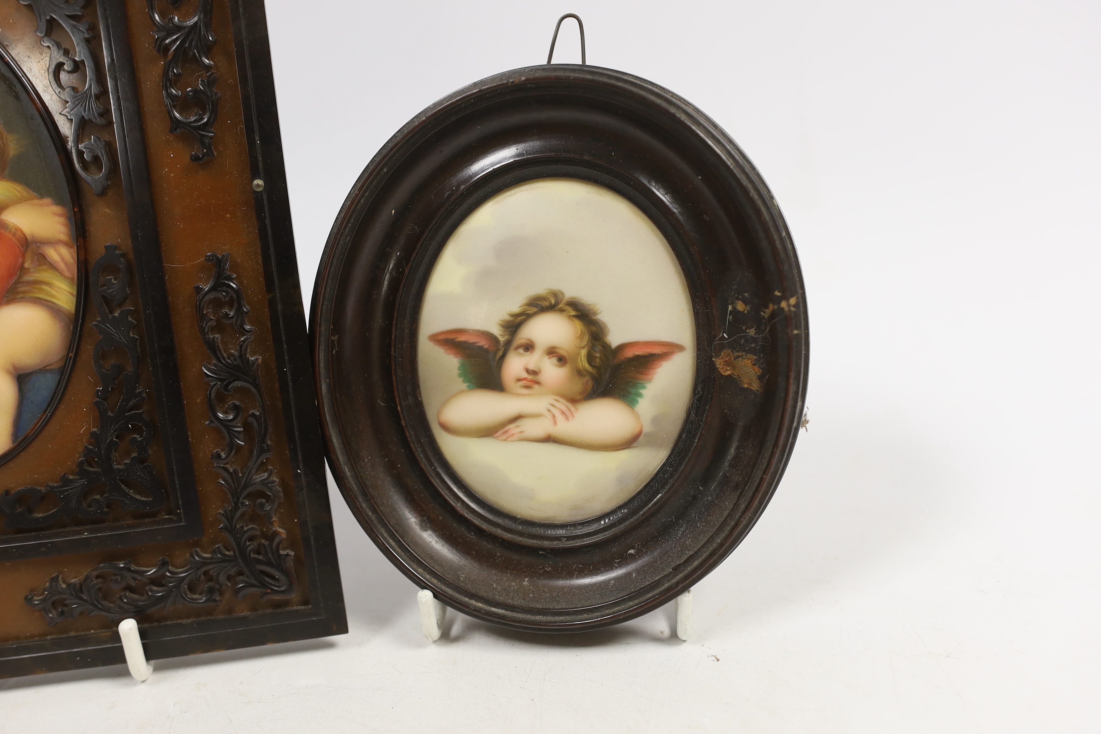 An oval porcelain plaque of mother and child in an ornate frame and a smaller circular porcelain plaque of a putti, mother and child plaque 10.5cm high